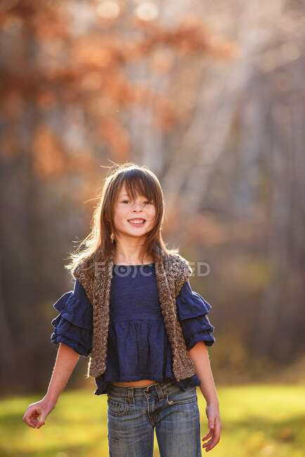 Retrato de una chica sonriente de pie en el jardín, Estados Unidos - foto de stock