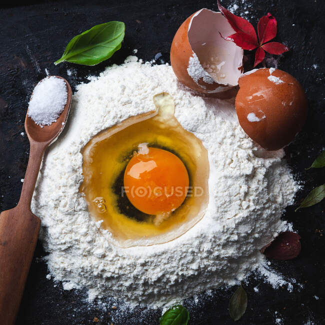 Uovo crudo e ingredienti su sfondo scuro. — Foto stock