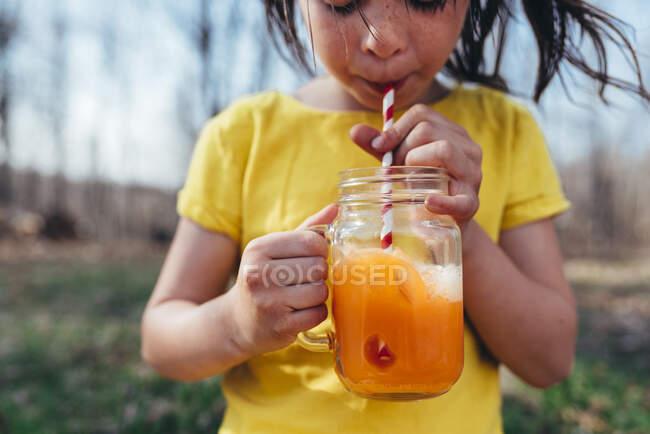 Девушка наслаждается летним напитком на открытом воздухе — стоковое фото
