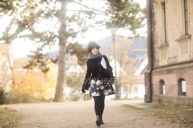 Frau läuft mit Papierkram auf Fußweg, Deutschland — Stockfoto