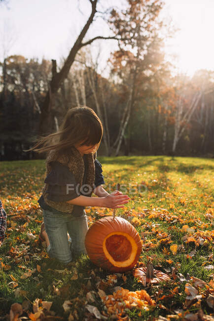 Menina esculpindo uma abóbora de Halloween no jardim, Estados Unidos — Fotografia de Stock
