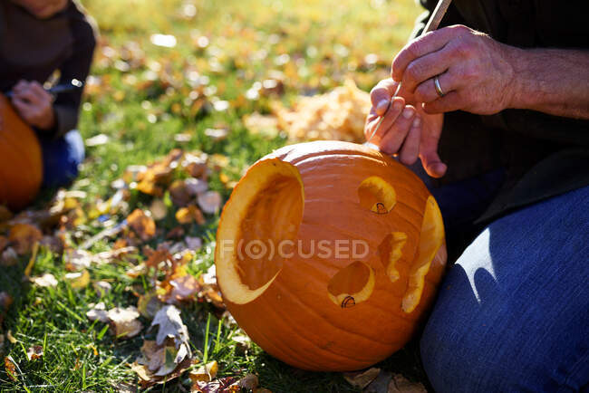 Father and son carving Halloween pumpkins, United States — Stock Photo