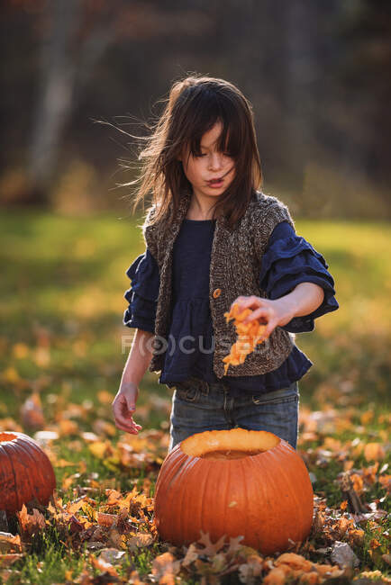 Девочка, вырезающая в саду куклу на Хэллоуин, США — стоковое фото