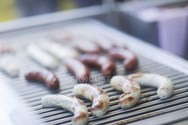 Vista close-up de salsichas grelhando em um churrasco — Fotografia de Stock