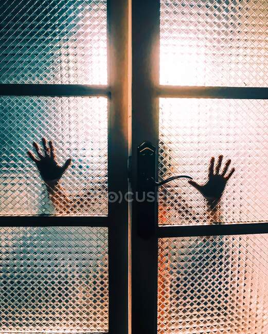 Persons hands seem through glass doors — Stock Photo