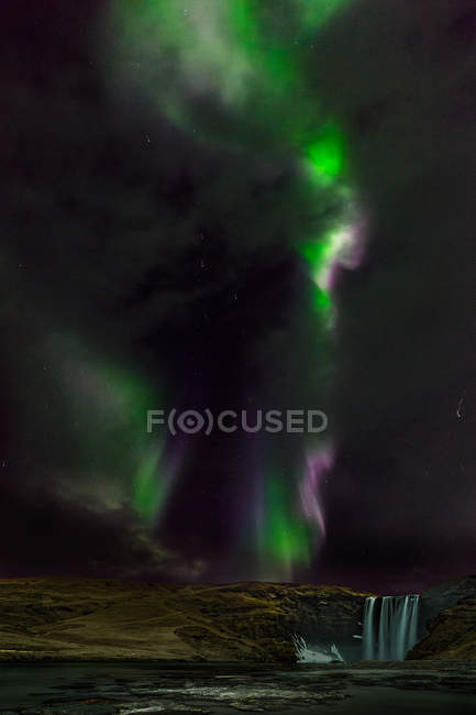 Scenic view of Northern lights over skogarfoss waterfall, Southern Region, Iceland — Stock Photo