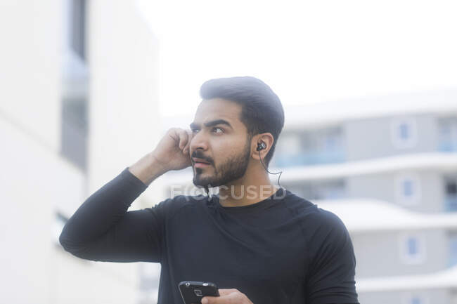 Человек слушает музыку на своем смартфоне во время пробежки — стоковое фото