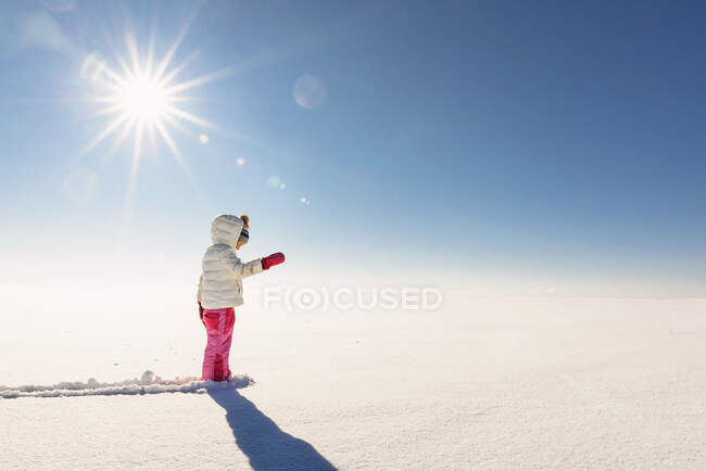 Girl standing in a snowy rural landscape — Stock Photo