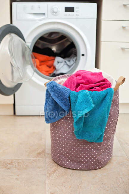 Cestino per il bucato davanti alla lavatrice — Foto stock