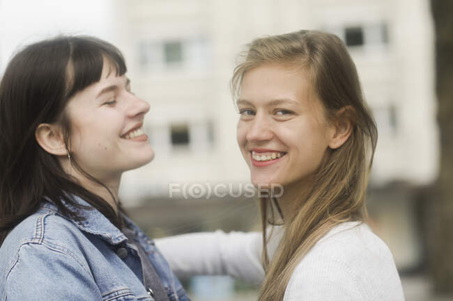 Dos mujeres sonrientes saludándose - foto de stock