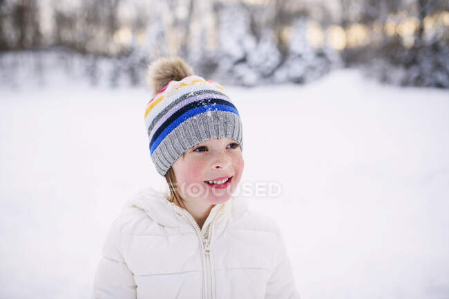 Ritratto di una ragazza in piedi sulla neve — Foto stock