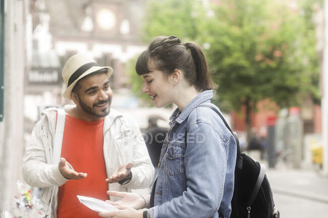 Coppia sorridente in piedi fuori da un negozio — Foto stock