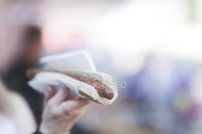 Cropped image of woman holding a hotdog — Stock Photo