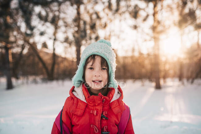 Ritratto di una ragazza sorridente in piedi sulla neve — Foto stock