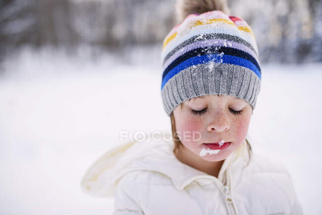Ritratto di ragazza in piedi sulla neve con la neve sul viso — Foto stock