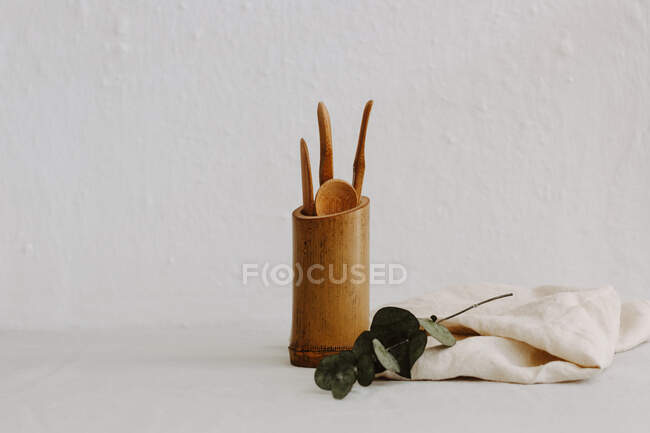 Set of wooden kitchen utensils, linen napkin and eucalyptus — Stock Photo
