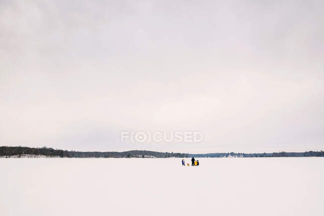 Family ice fishing on a frozen lake — Stock Photo