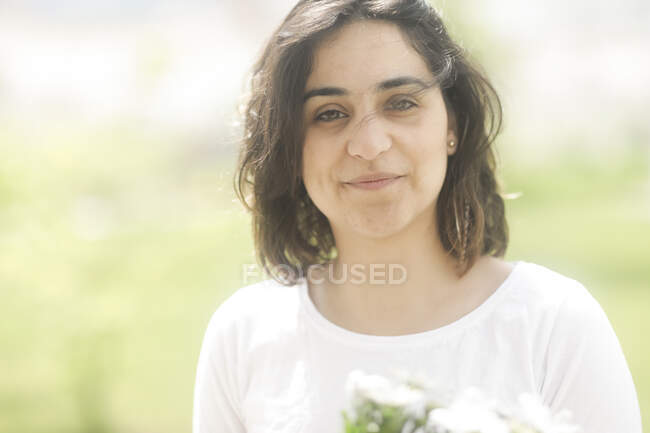 Portrait of a smiling woman standing in a garden — Stock Photo