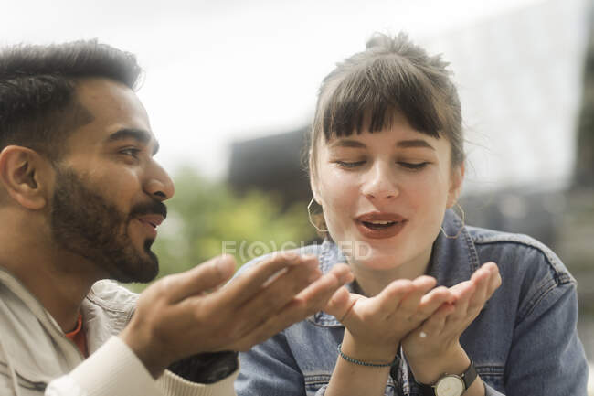 Sorridente coppia che soffia sulle loro mani — Foto stock