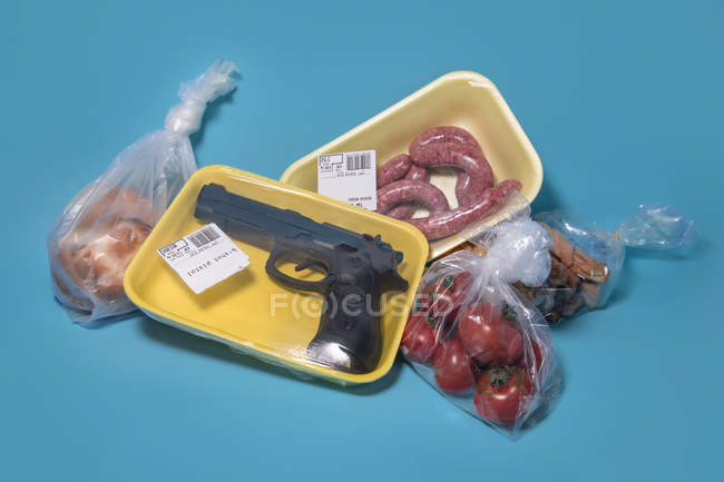 Gun shrinkwrapped for sale with food at a supermarket — Stock Photo