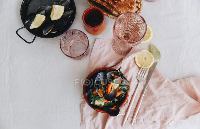 Overhead view of Steamed mussels with lemon and toast — Stock Photo