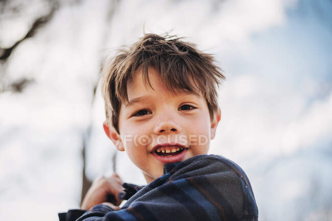 Ritratto ravvicinato di un ragazzo sorridente su un'altalena — Foto stock