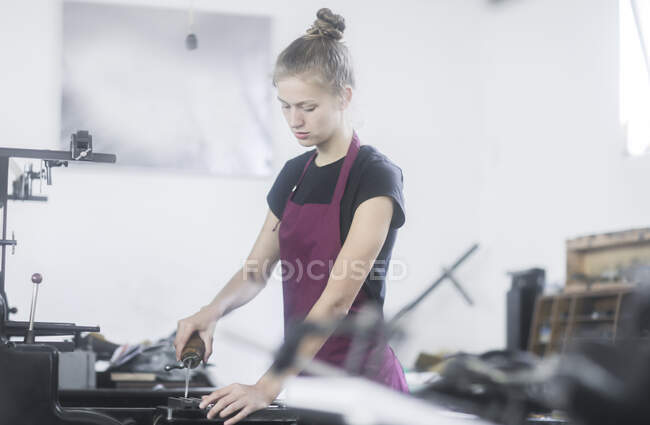 Woman operating a printing press in a factory — Stock Photo