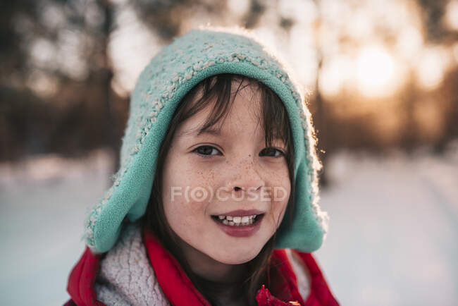 Portrait d'une fille souriante debout dans la neige — Photo de stock