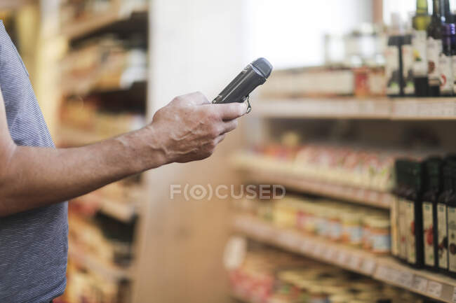 Помощник продавца с помощью цифрового устройства для проверки продуктов — стоковое фото
