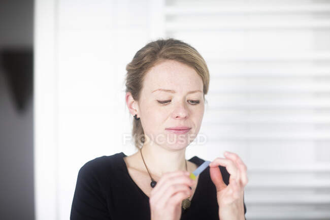 Portrait of a woman filing her nails in the bathroom — Stock Photo