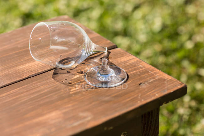 Broken wine glass on a wooden bench — Stock Photo