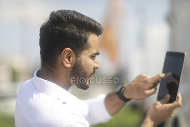 Man standing outdoors taking a photo using a digital tablet — Stock Photo