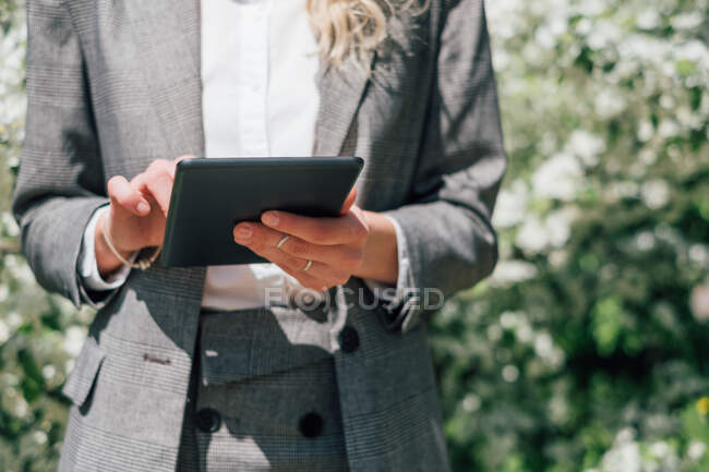 Donna d'affari in piedi all'aperto utilizzando un tablet digitale — Foto stock