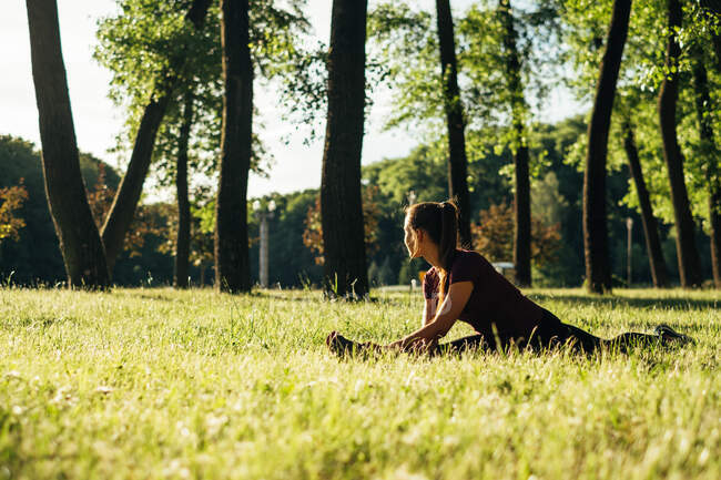 Woman sitting in the park stretching, Minsk, Belarus — Stock Photo