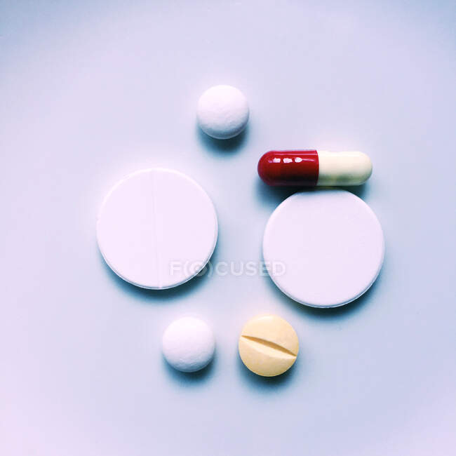 Pills and capsule on white surface, toned shot — Stock Photo