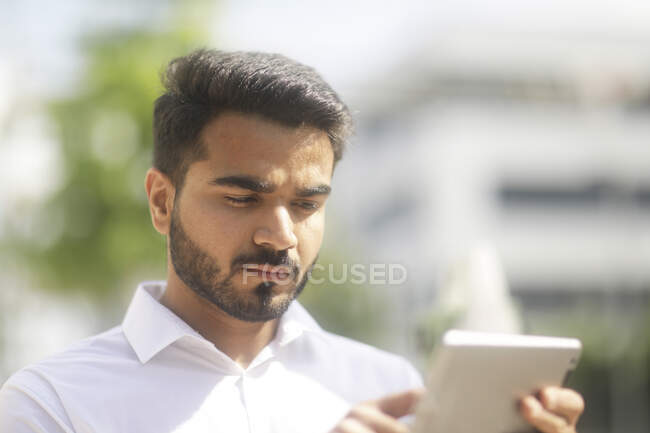 Man standing outdoors using a digital tablet — Stock Photo