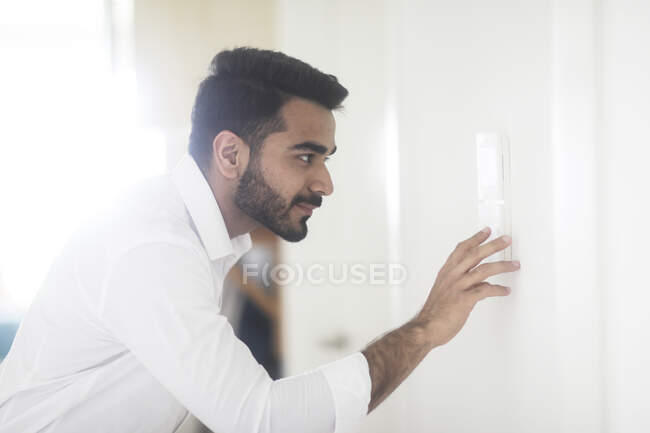Man setting a digital control on the wall — Stock Photo