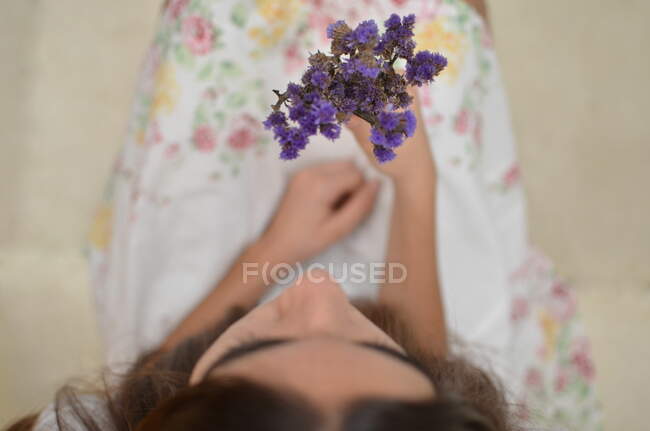 Дівчина тримає букет фіолетових квітів — стокове фото