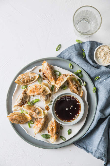 Gyoza dumplings with dipping sauce, top view — Stock Photo