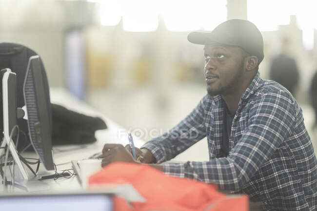 Man sitting at desk working with a safety vest next to him — Stock Photo