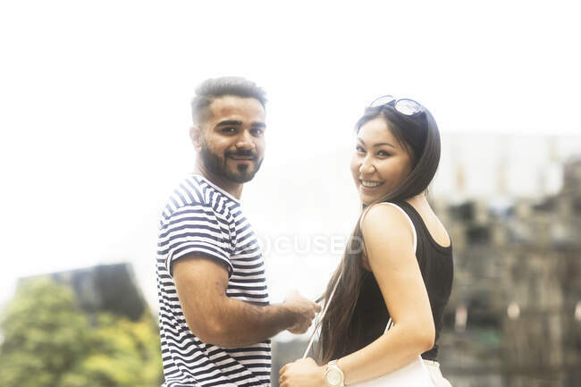 Portrait of a smiling couple standing in a city square — Stock Photo