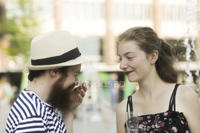 Portrait of a smiling couple standing in city making a celebratory toast — Stock Photo