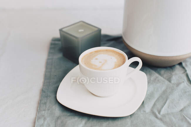 Tazza di caffè accanto a un vaso e candela — Foto stock