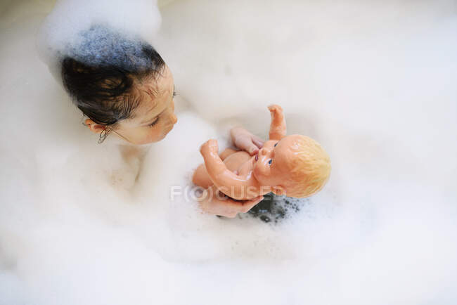 Jovem brincando em um banho de espuma — Fotografia de Stock