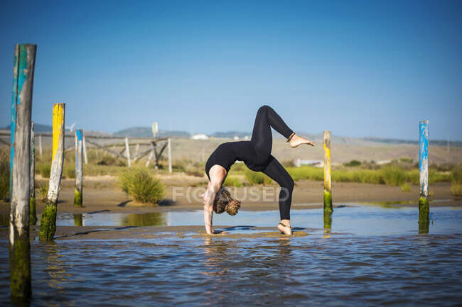 Женщина делает йогу вверх лук позы, пролива природный парк, тарифа, кадис, andalusia, Испания — стоковое фото