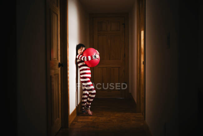 Ragazza in piedi nel corridoio in possesso di una palla gigante — Foto stock