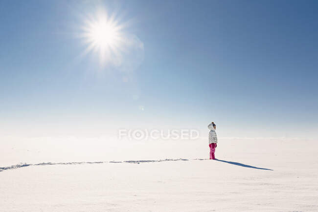Девушка, гуляющая по заснеженной сельской местности — стоковое фото