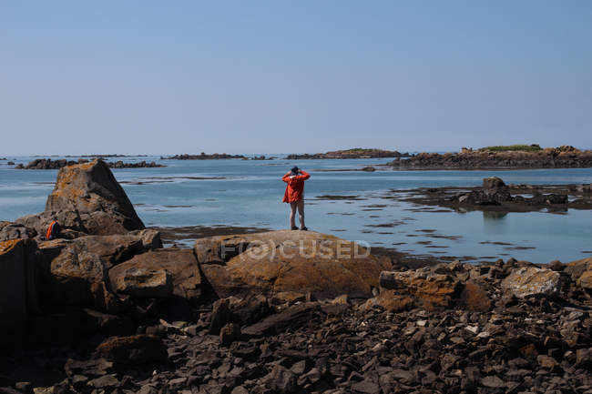 Жінка стоїть на пляжі, дивлячись на вид: острови Чозі, Нормандія, Франція. — стокове фото