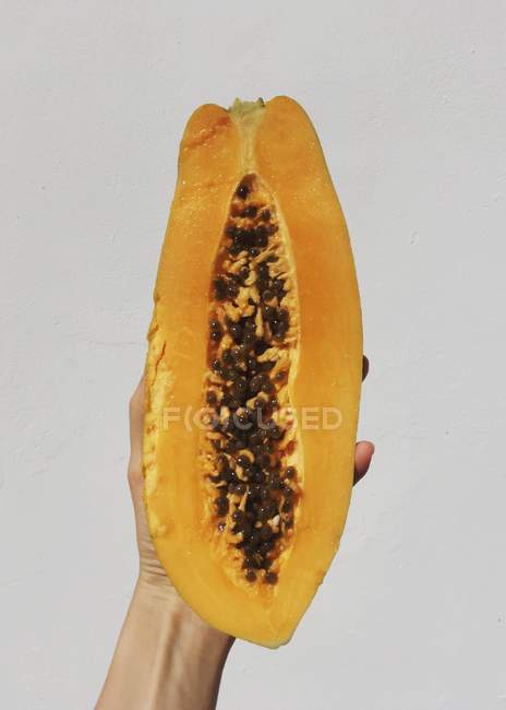 Mujer mano sosteniendo una fruta de papaya — Stock Photo