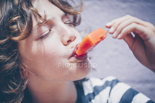 Garçon manger un lolly glacé — Photo de stock